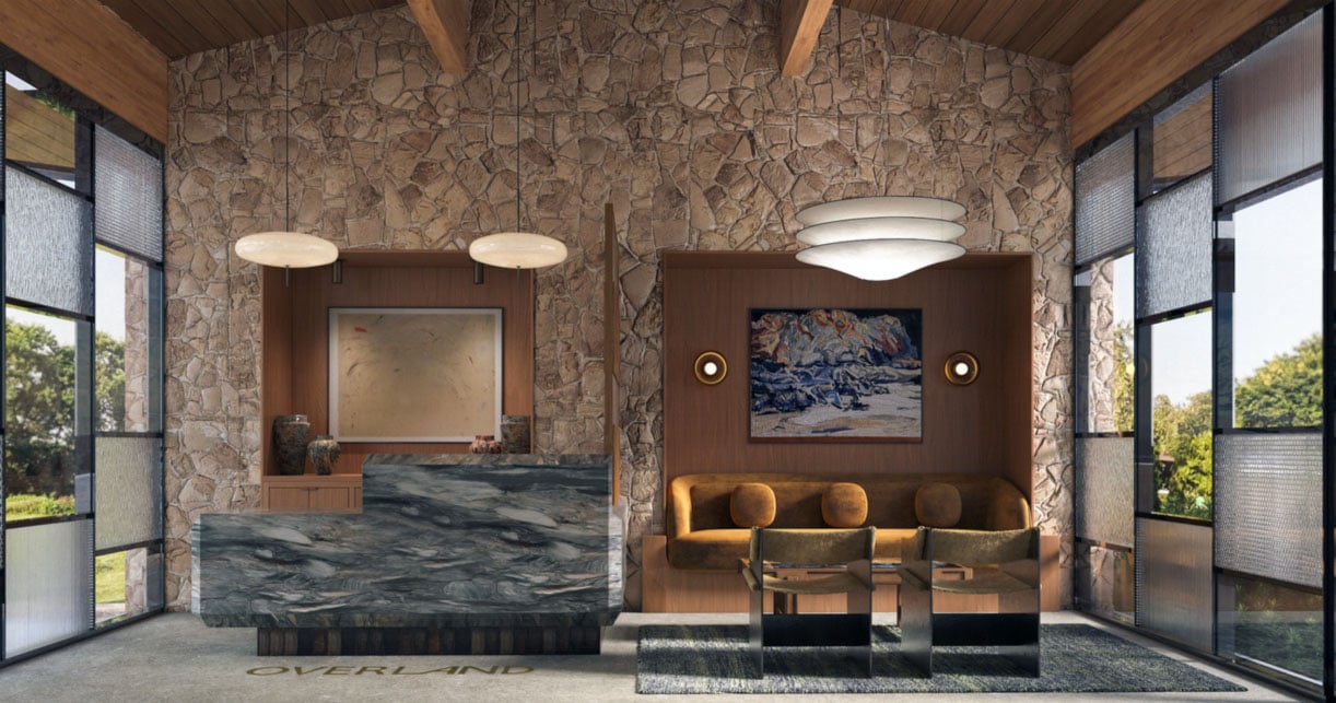 Modern hotel lobby reception area with a marble counter, stone walls, warm lighting, and seating area.