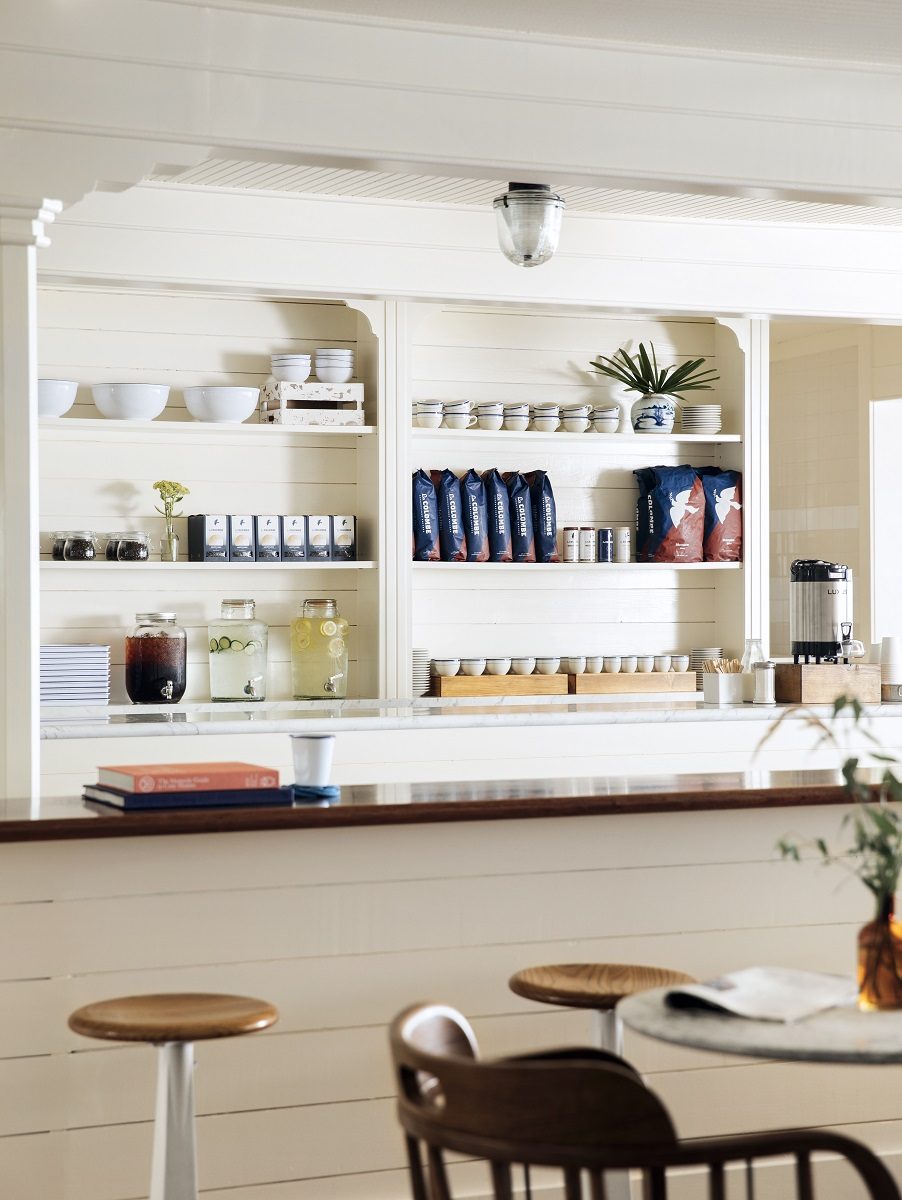 White café shelving stocked with jars, cups and coffee
