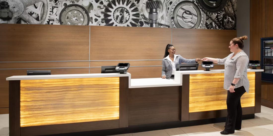 Front desk associate handing a key card to a guest
