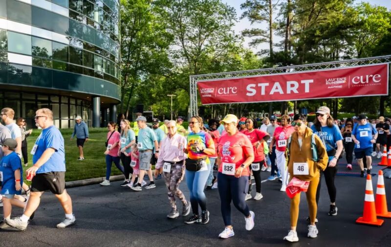 Runners crossing a START banner at a community fun run
