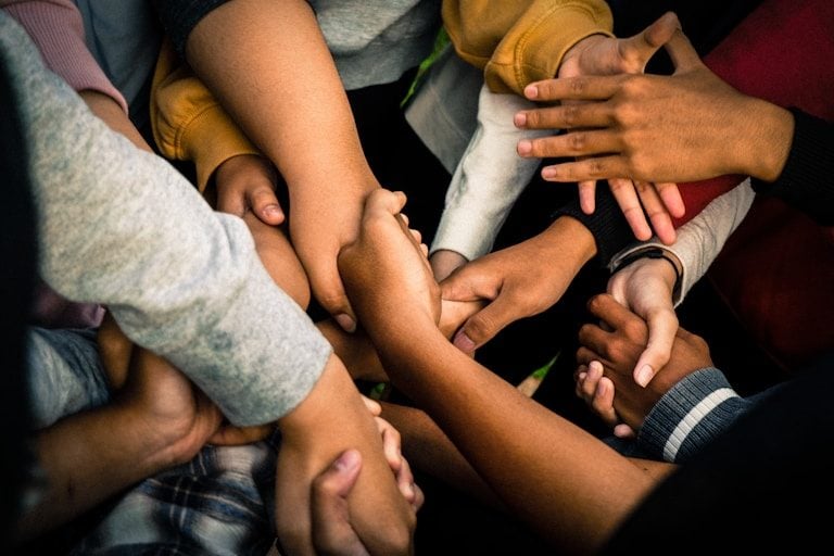 A group of hands stacked together in a huddle