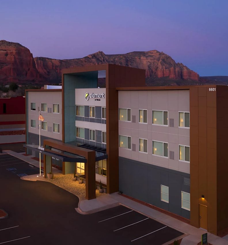 Dual-brand hotel exterior with red rock cliffs behind