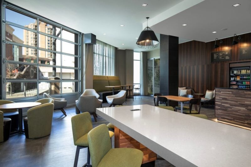 Bright hotel dining lounge with a long communal table