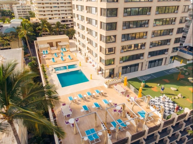 Aerial view of the outdoor pool deck at Holiday Inn Express Honolulu with sun loungers and cabanas.