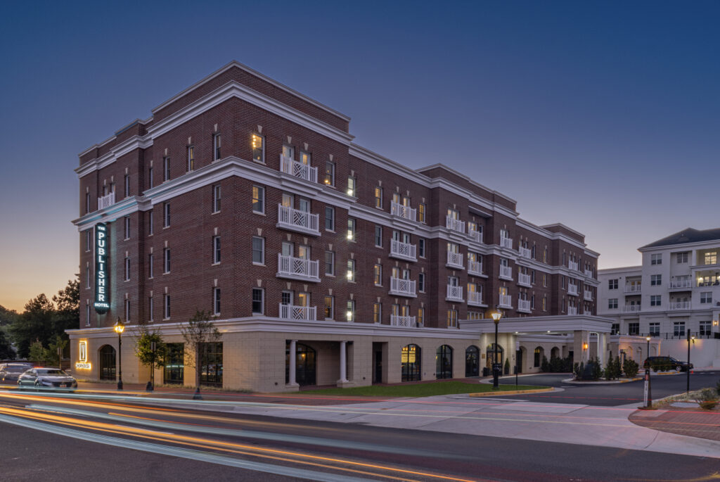 The Publisher hotel, a brick building lit up at dusk